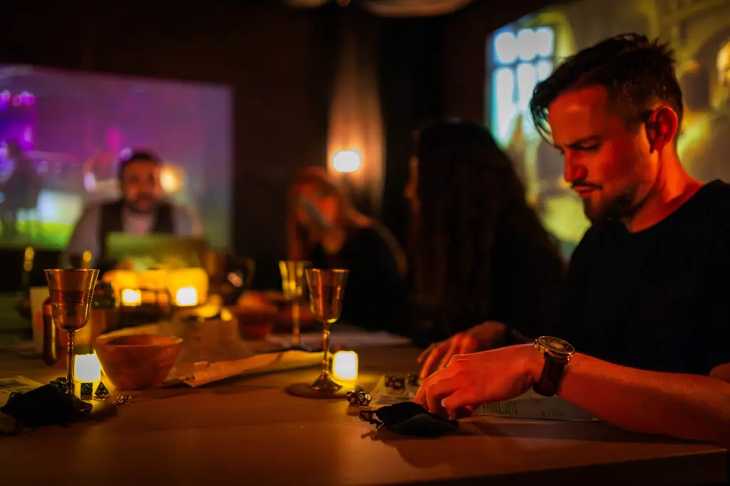 Joueurs concentrés autour d'une table, lumières violettes et bougies