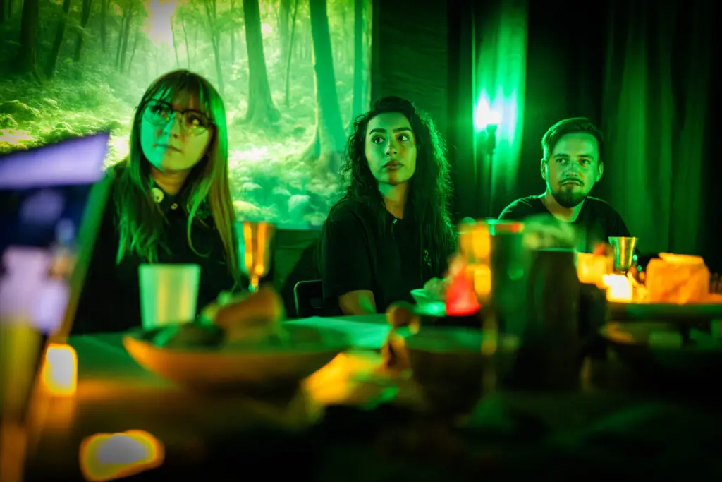 Joueurs devant un décor de forêt projeté, lumière verte