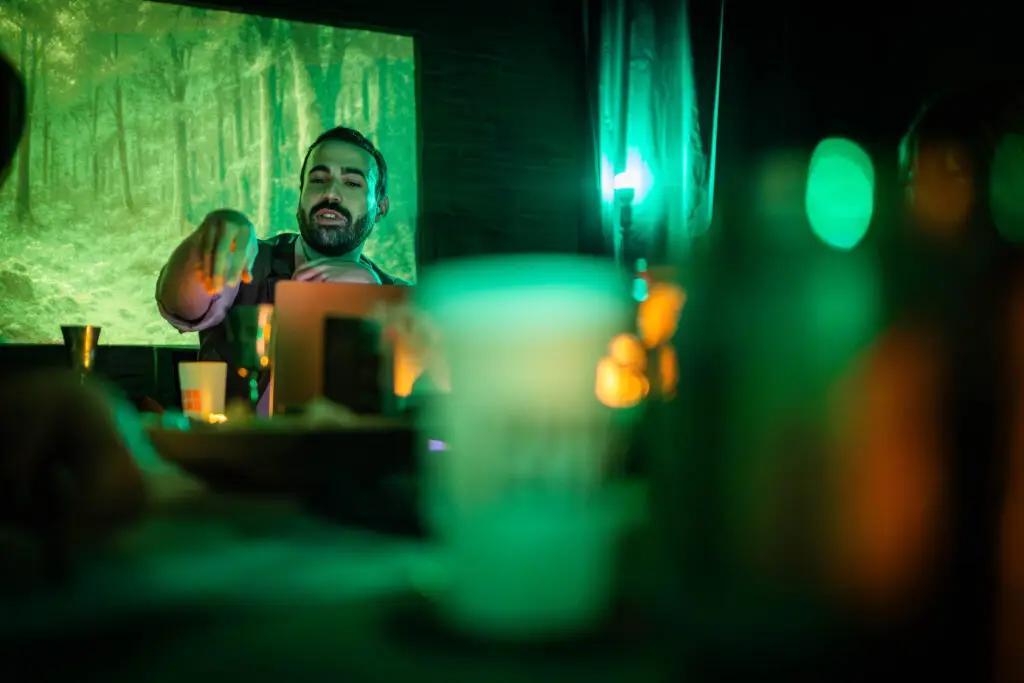 Maître du jeu et bougies devant une forêt projetée
