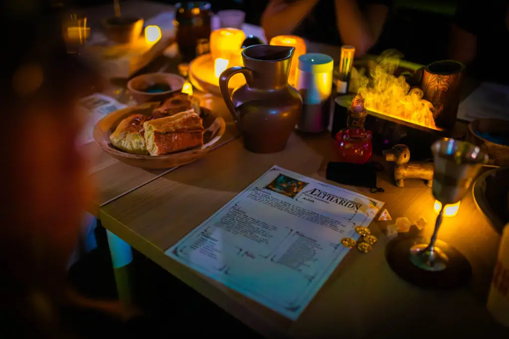 Table de taverne garnie de gobelets, de plats et de parchemins